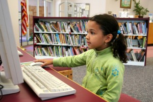 Kind in Bibliothek am Computer
